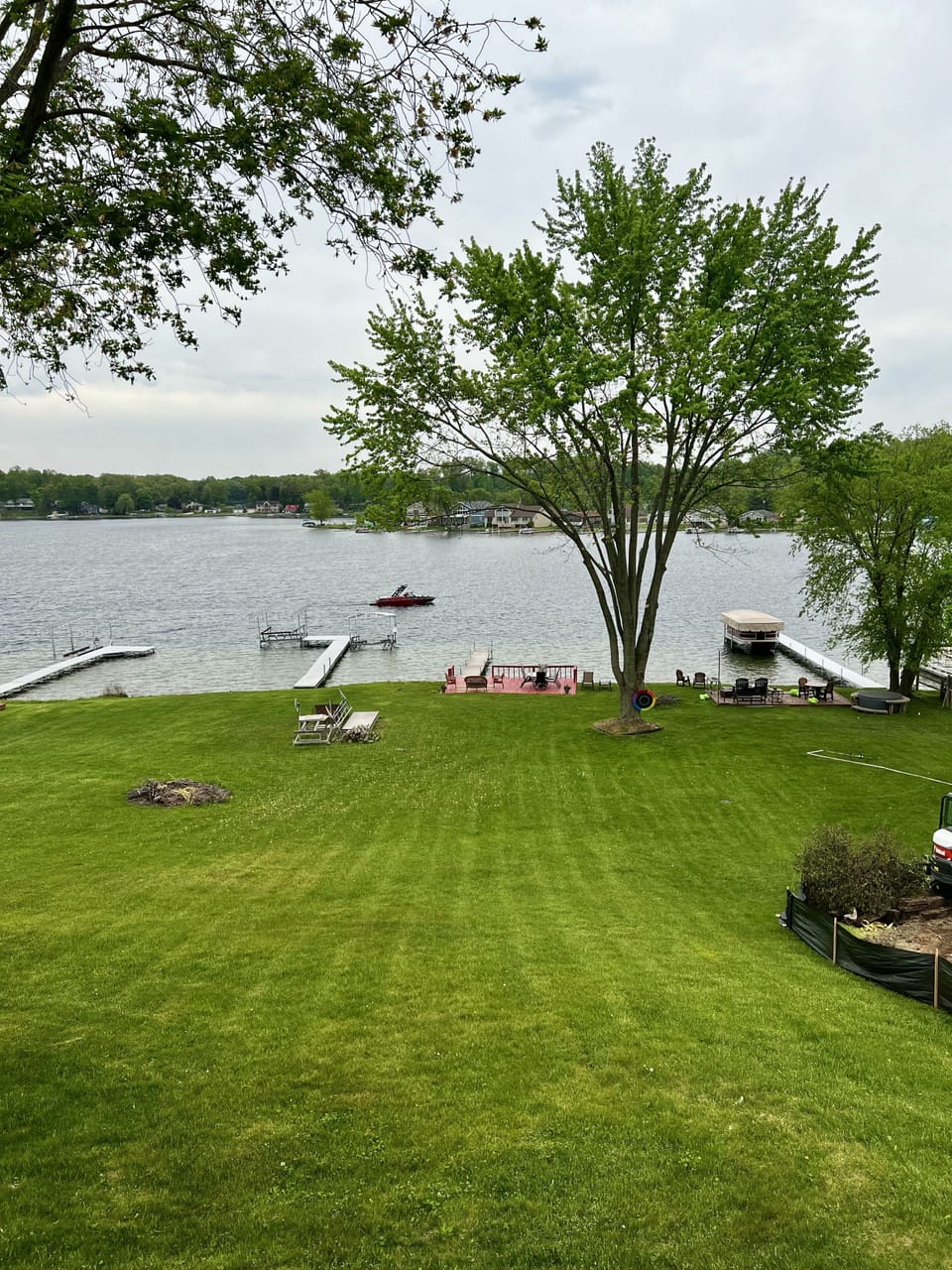 Sandy water front with deck, fire pit, pier, and swim platform.