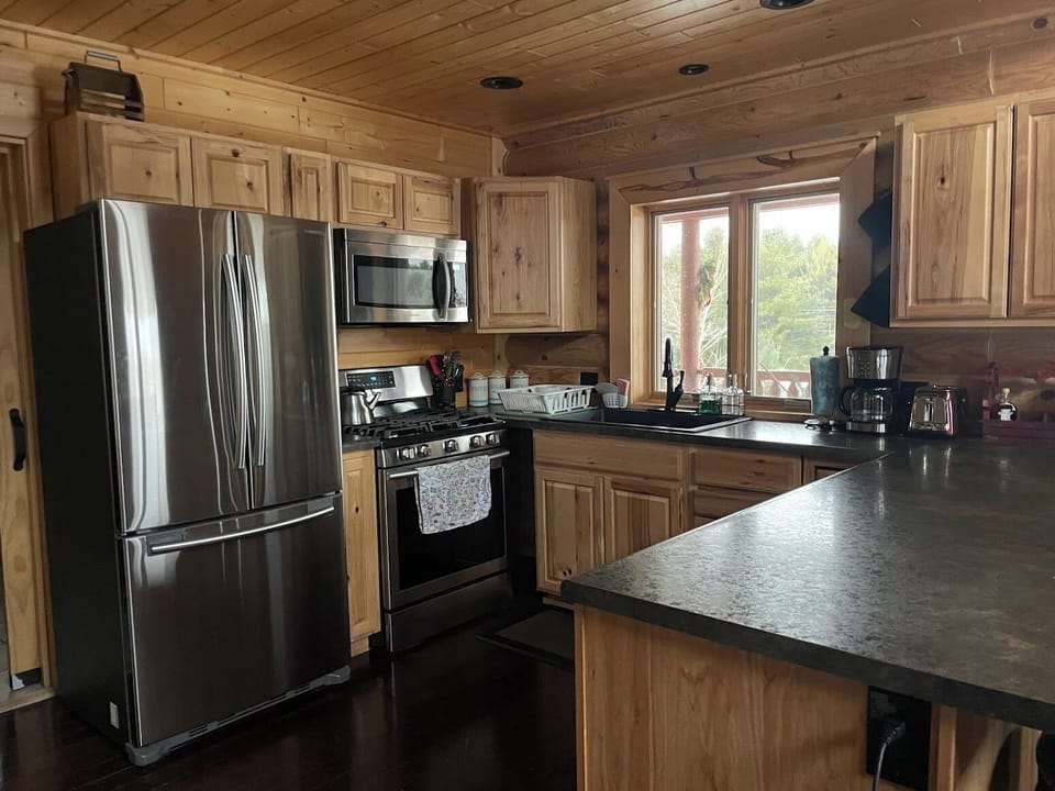 Gas stove in Kitchen with pots/pans and dishes all there
