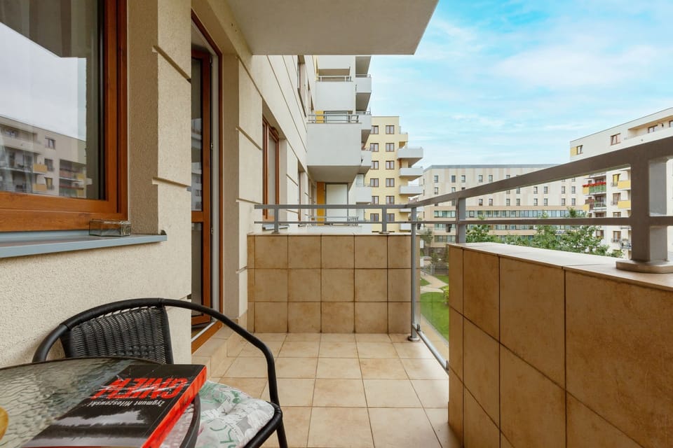 Furnished balcony with green surroundings. 