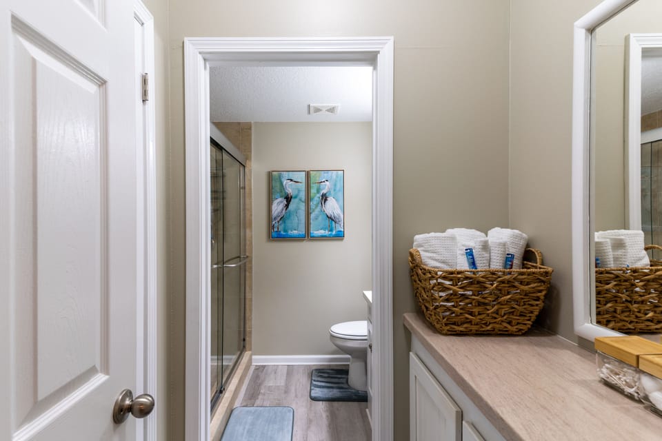 Master tile shower bath with well stocked separate vanity and closet.
