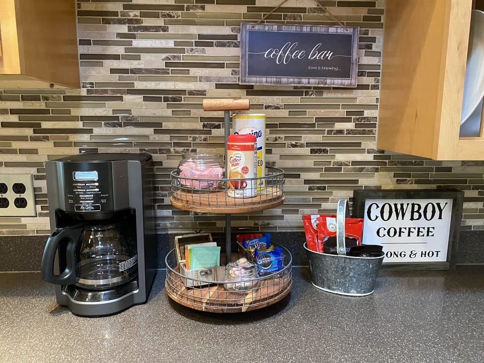 The coffee bar is equipped with a coffee maker, coffee, cocoa, and an assortment of teas.