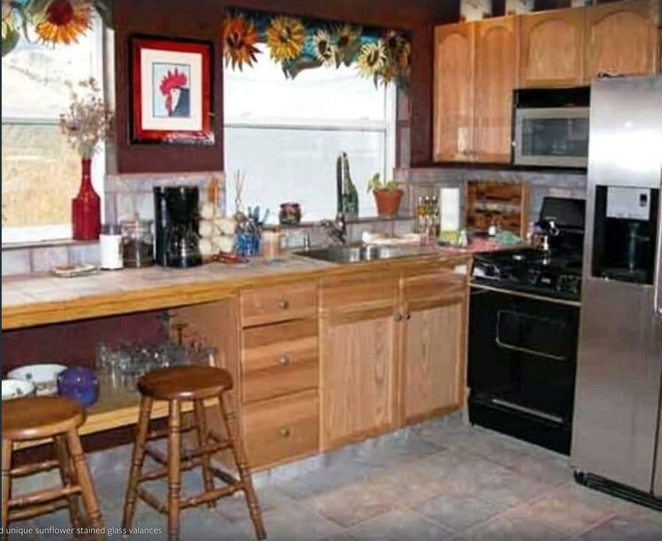 Well supplied kitchen with lovely stained glass sunflower valances