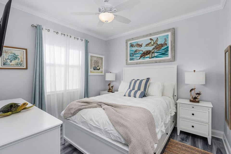 Guest bedroom with queen size bed, smart TV and ample closet space for clothes storage.