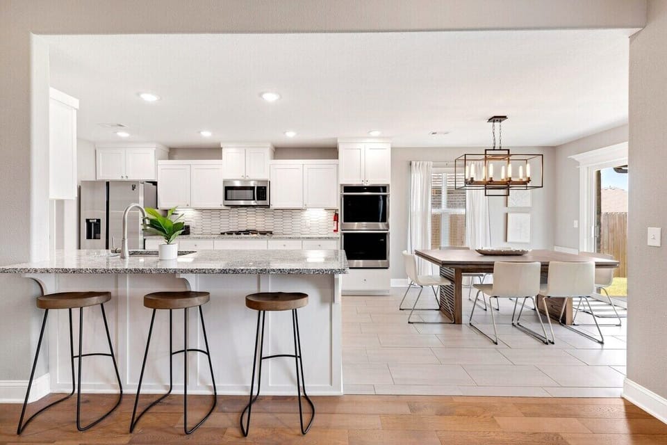 A stunning kitchen with granite countertops and a dining table for 6. Approach our back patio through sliding doors!