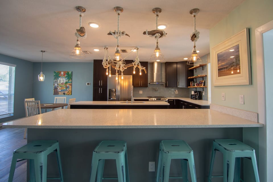 Large chef's kitchen with themed driftwood lighting.