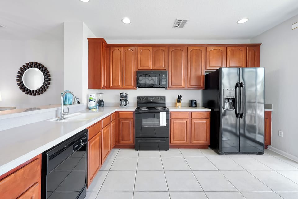 Your fully equipped kitchen features rich wood cabinetry, sleek stainless appliances, and spacious counters for preparing memorable meals together.