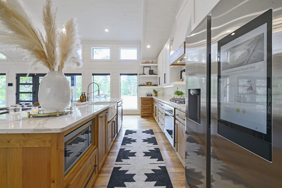 A chef’s dream kitchen with high-end stainless steel appliances, ample counter space, and a stylish combination of modern and rustic design elements for a luxury cooking experience.