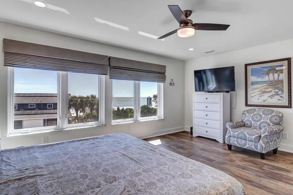 - Start your mornings with breathtaking ocean views from this king bedroom retreat
- Flat screen TV, printed accent chair, and artwork create a relaxing ambiance
- Four large windows frame beach and palm views for a peaceful escape