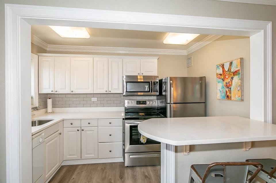 Modern kitchen setup w/ stove, fridge & ample counter space for easy cooking