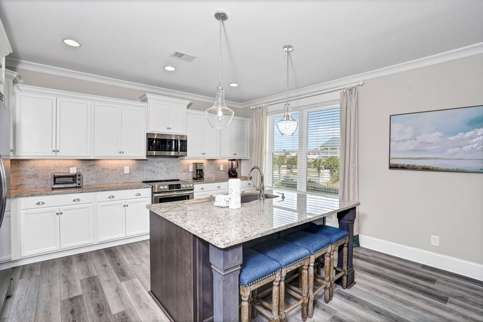 Your gourmet kitchen awaits with granite countertops, gleaming appliances, and a spacious island perfect for cooking memorable meals together.