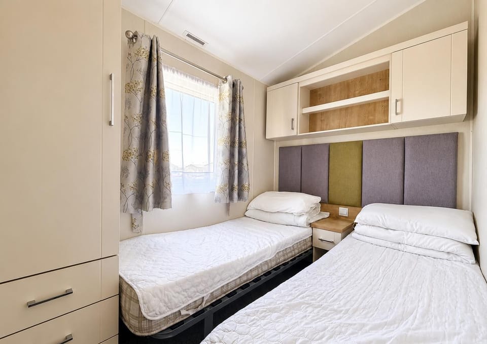 Cozy twin bedroom with soft natural light and storage