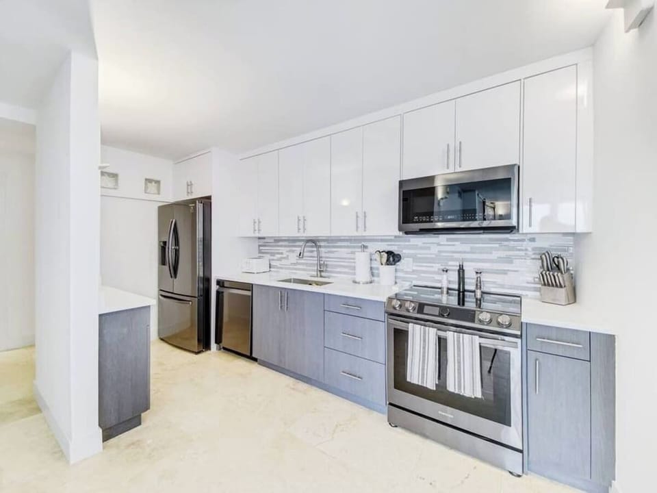 The kitchen is stocked with a full set of appliances including a refrigerator and basic kitchen utensils. 