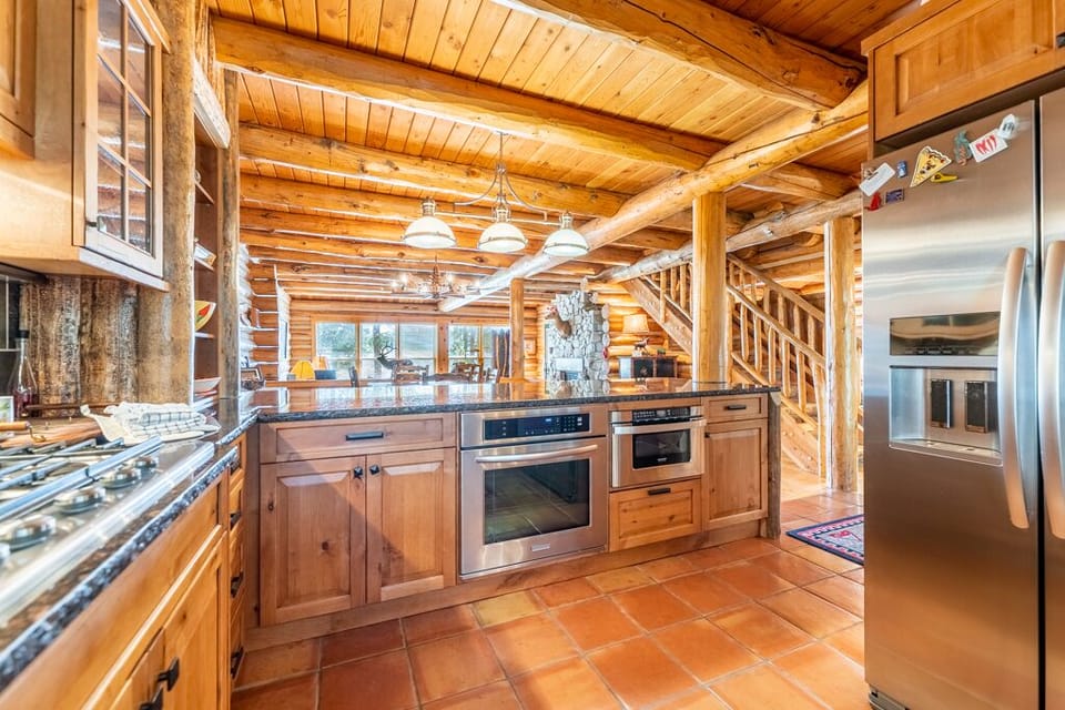 Kitchen with ample granite countertops, a farmhouse sink, and stainless steel appliances