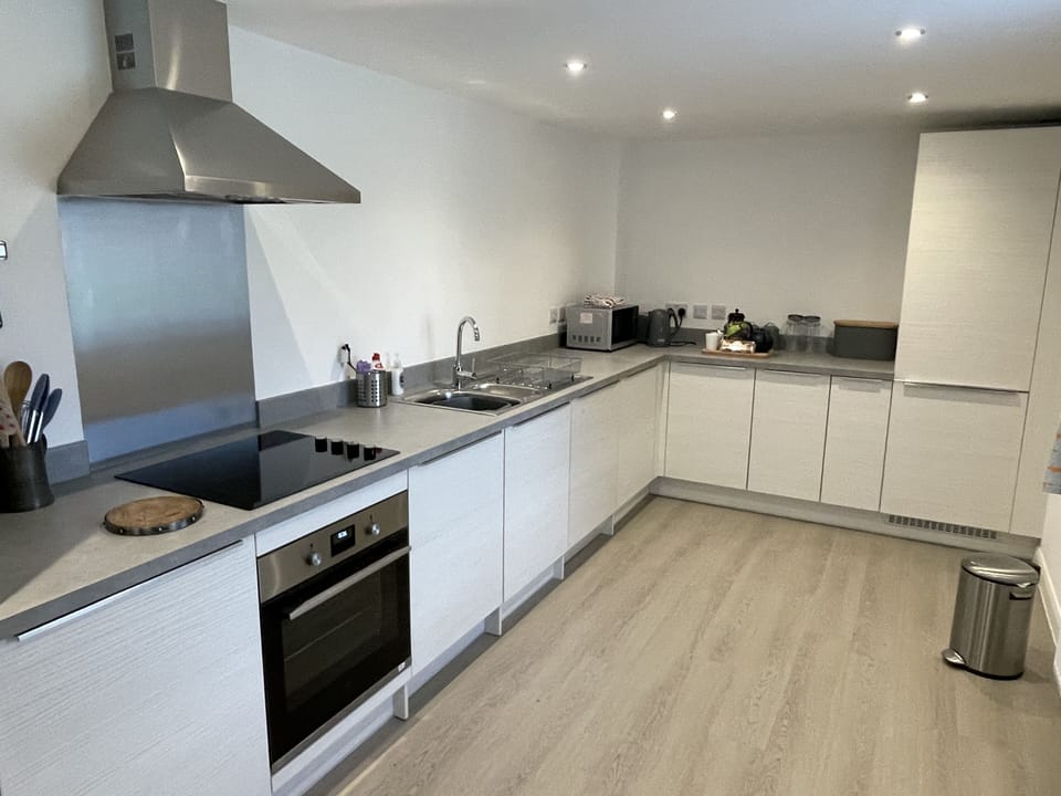 A large kitchen with oven, hob, dishwasher, washing machine, fridge, freezer.