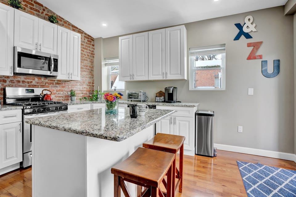 The kitchen, with its island workspace and abundant natural light, serves as much more than a place for cooking and eating. It doubles as an extra workspace, ideal for tasks requiring ample surface area
