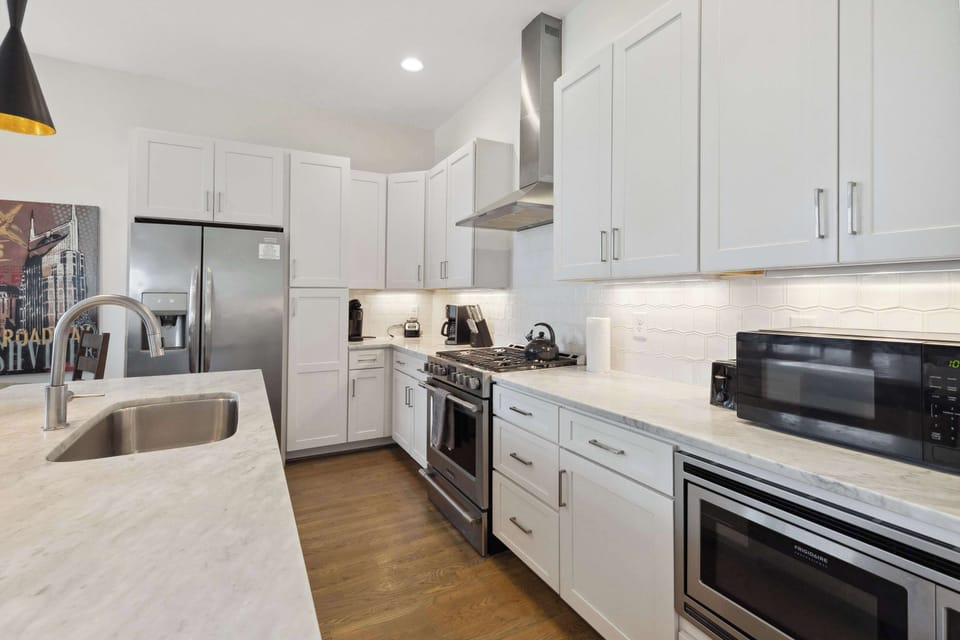 Cooking is a joy in our modern white kitchen, complete with stainless steel appliances and all essentials.