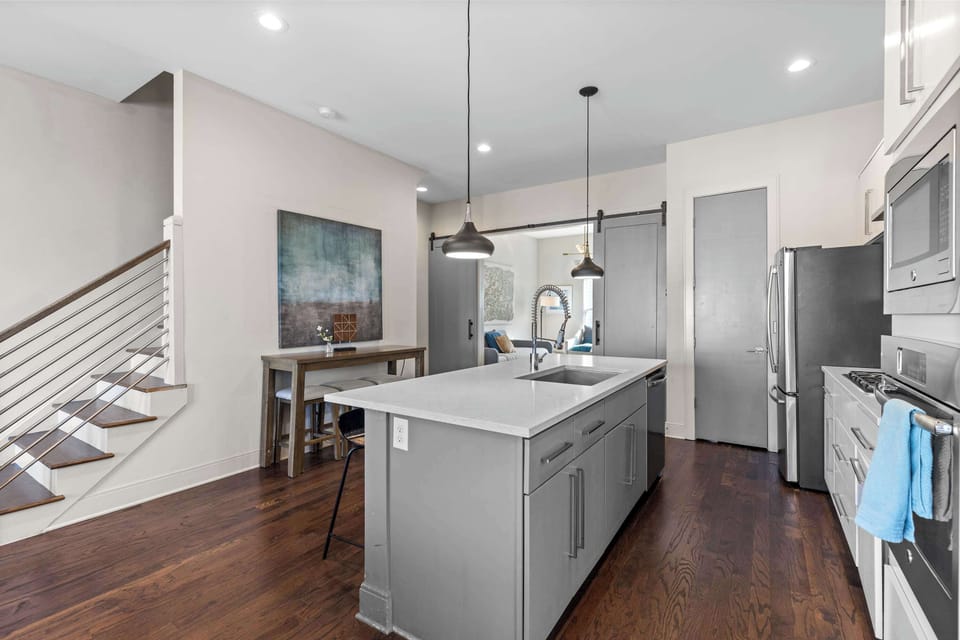 Stay social while you cook in this open, modern kitchen with chic stairs!