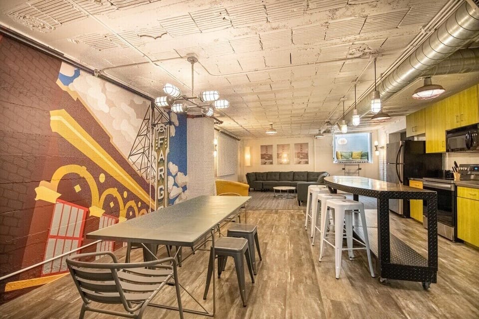 Enjoy and take in the custom wall art and graphics throughout the space.  Here, a large, open-concept space features a full kitchen, a dining area and a giant living room complete with a projector and screen.