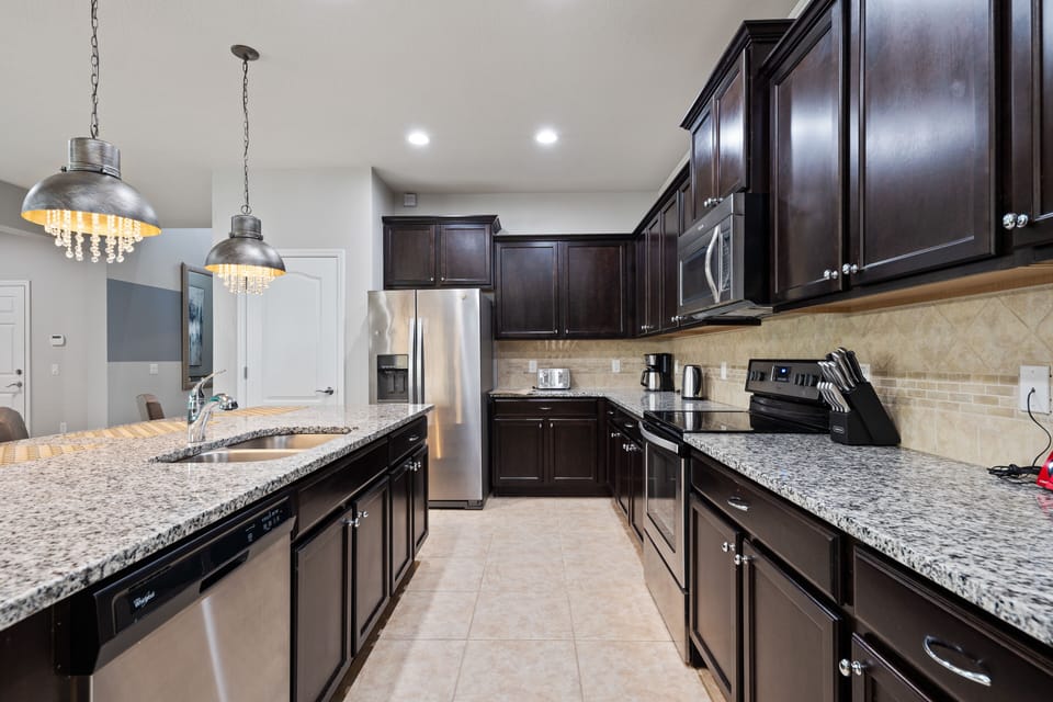 Elegant kitchen area with oven, microwave, refrigerator and dish washer