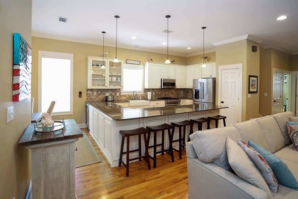 - Spacious kitchen with a large central island, perfect for cooking or casual dining - Modern white cabinetry & sleek granite countertops create a bright, inviting space - Includes stylish barstools for seating & easy access to the living area