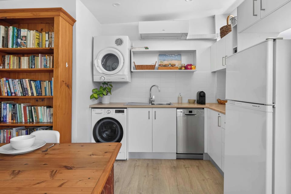 Fully equipped kitchen featuring a refrigerator, dishwasher, washing machine, and dryer, offering everything you need for a comfortable and convenient stay.