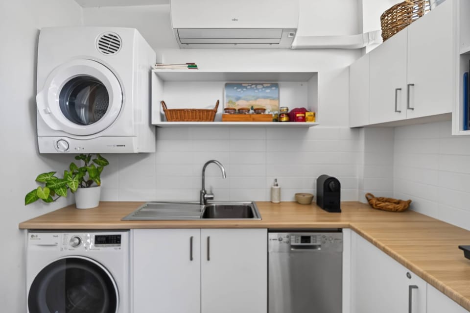 Fully equipped kitchen featuring a refrigerator, dishwasher, washing machine, and dryer, offering everything you need for a comfortable and convenient stay.