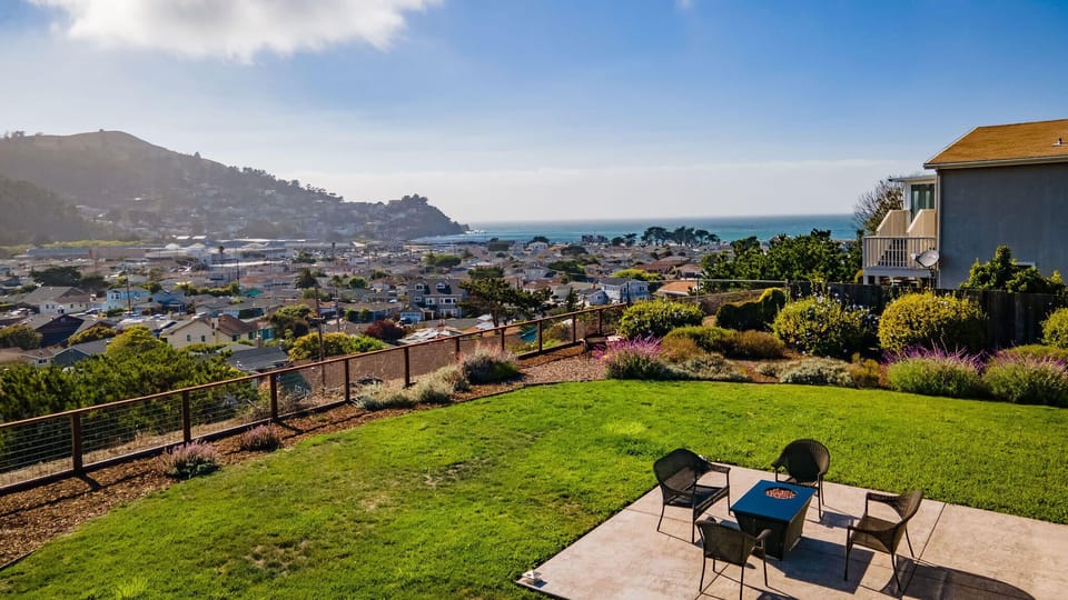 Spacious outdoor seating with table, chairs, and a beautiful ocean view