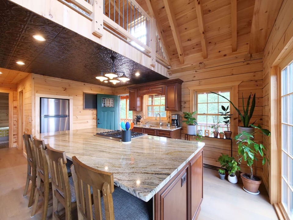 The kitchen features a granite island w/ built-in oven, range and microwave.
