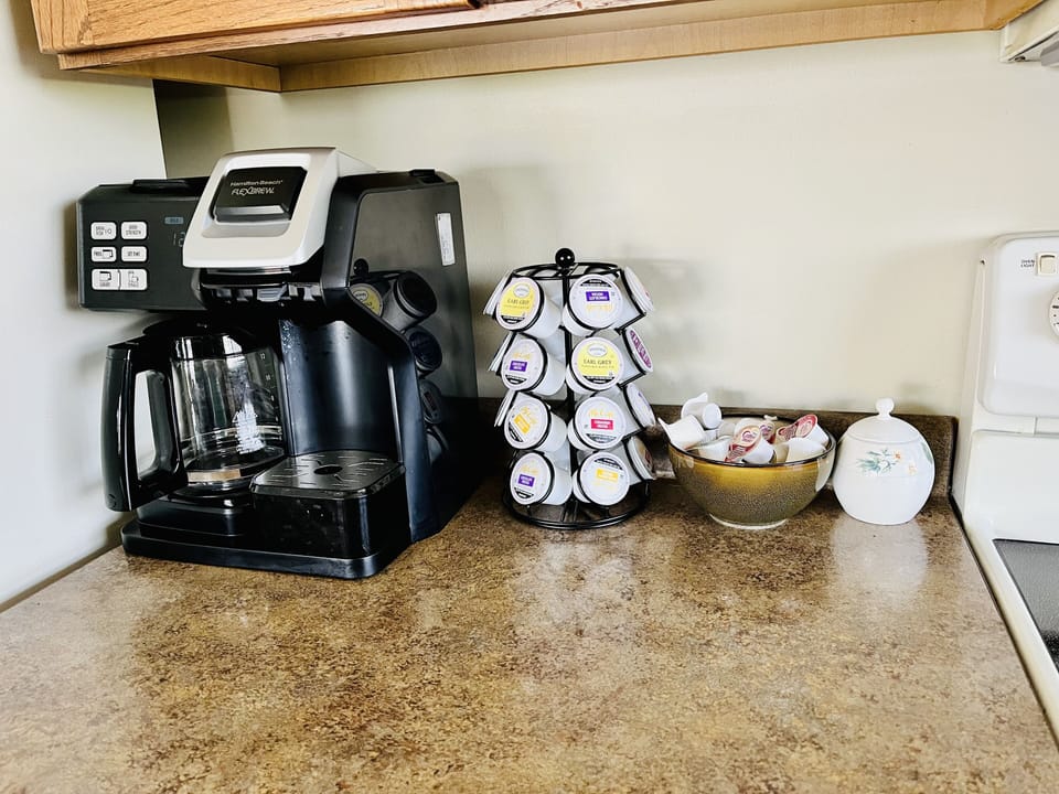 Full size coffee pot with coffee, filters, creamer, as well as a K-cup side. 