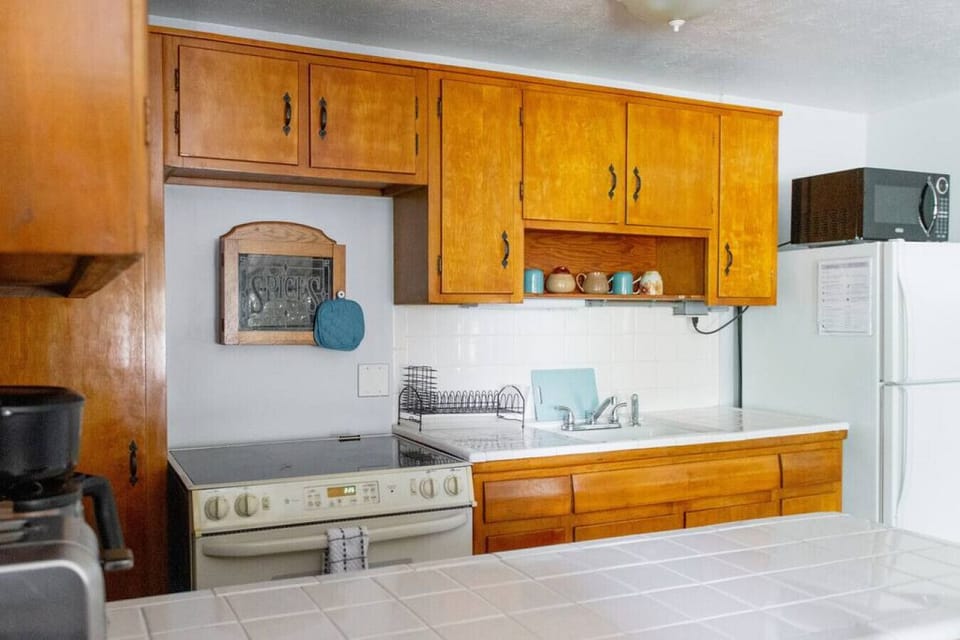 Kitchen includes refrigerator, microwave, oven, stove top, toaster, and coffee machine
