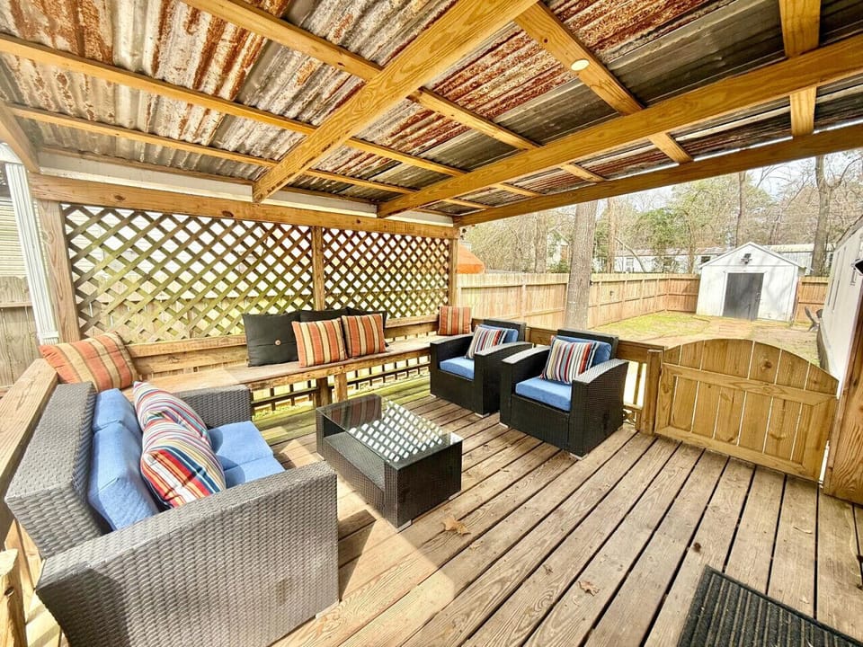 Covered patio lounge with privacy lattice and fenced backyard — a peaceful spot to unwind after a day on Lake Conroe.