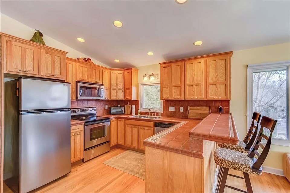 Kitchen with plenty of utensils, dishes, cooking items, mugs, and glasses. 