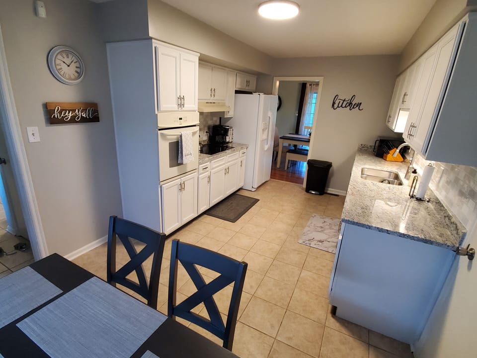 Fully equipped kitchen featuring white cabinetry, granite countertops, and modern appliances at Andrea Abode in Lexington, Kentucky — just minutes from the Kentucky Horse Park.