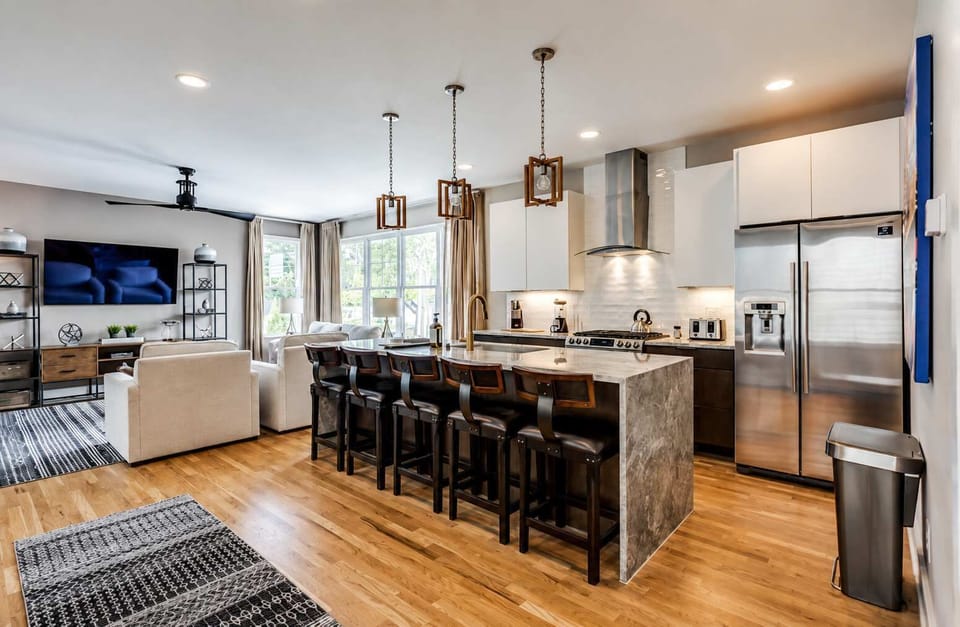 Modern kitchen and island counter with seating for five—your ideal coffee spot.