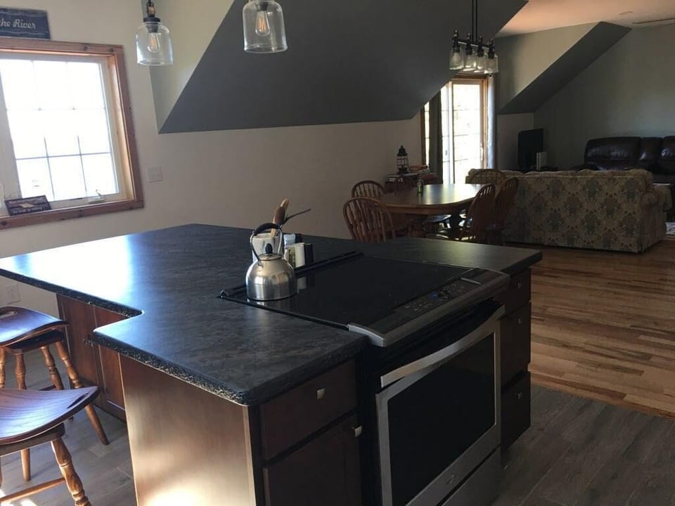 Kitchen island, dining room table, living area and access to balcony.