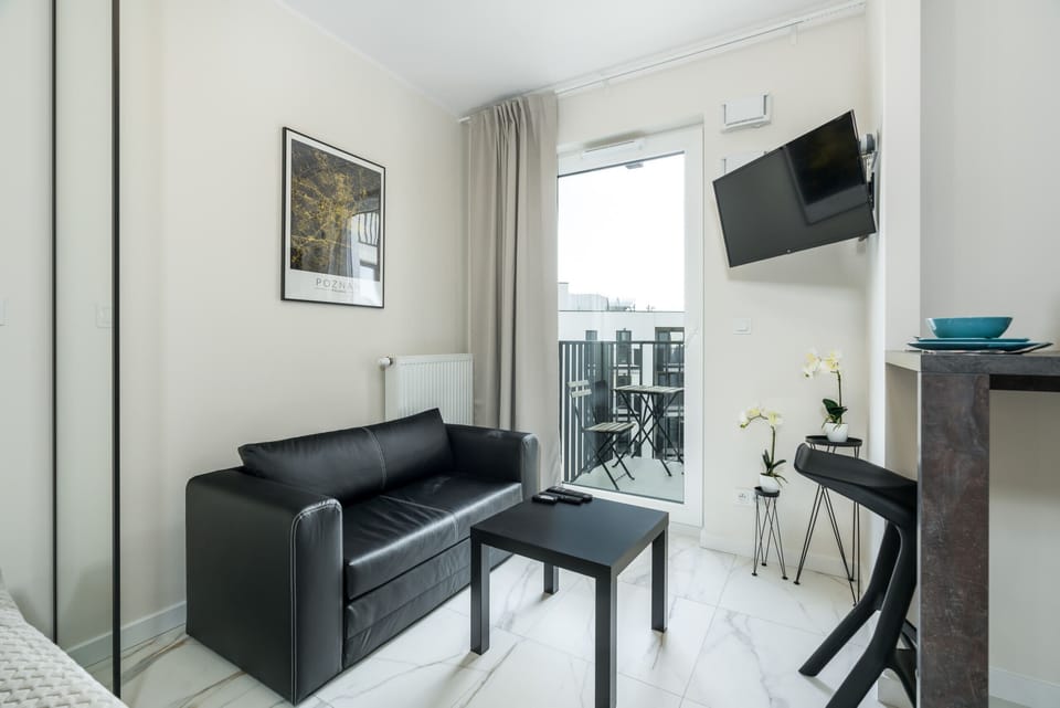A cozy workspace with a sleek black desk and chair, complemented by minimalist decor.
