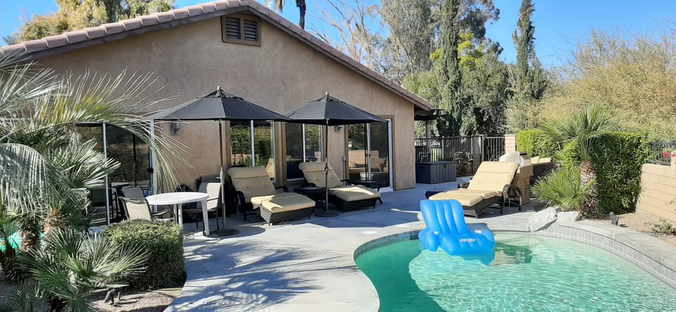 Pool area showing 3 luxurious double loungers & 2 large umbrellas