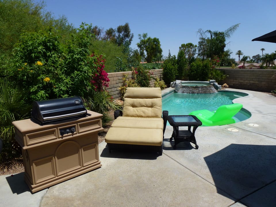 Pool area showing one of 3 luxurious double loungers & our old BBQ (replaced)