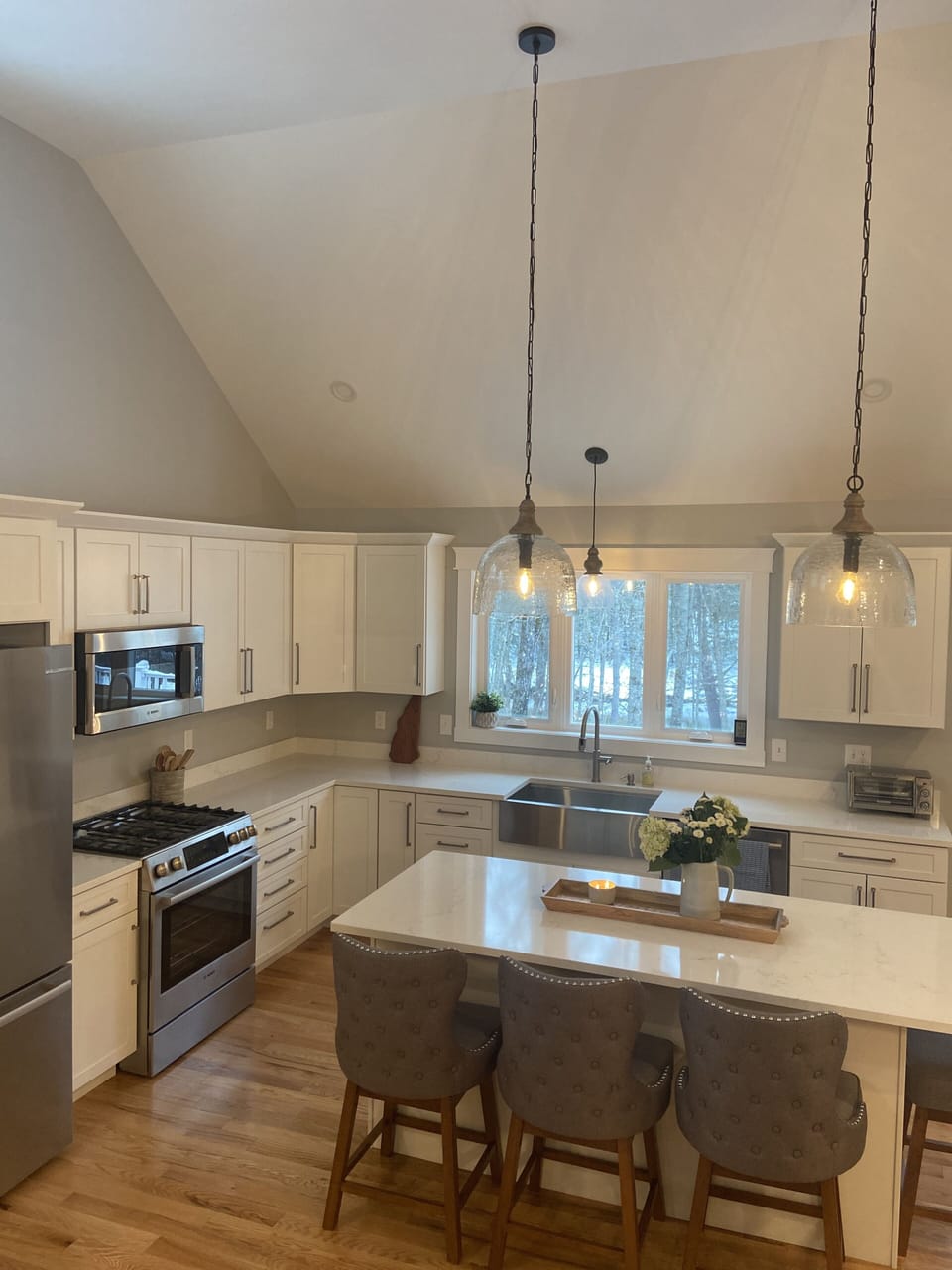 Kitchen with island seating for four and Bosch stainless steel appliances.