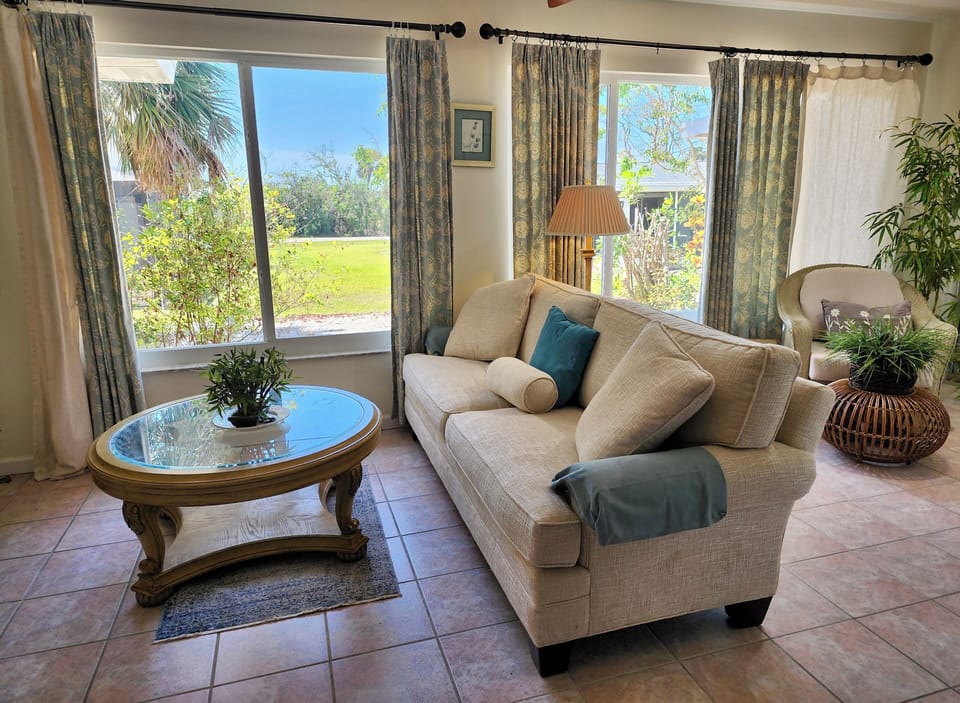 tv/sun room full windows with glass sliders that lead out to the lanai