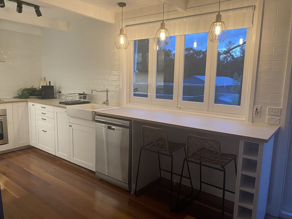 Kitchen with breakfast bar window opening onto outdoor patio facing the lake 