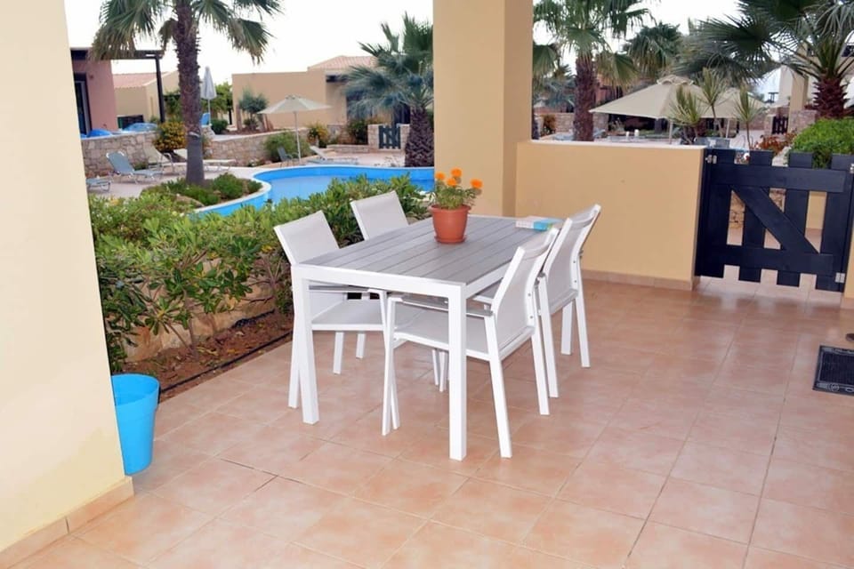 Covered terrace overlooking communal pool. Al fresco dining, outdoor sofa, table