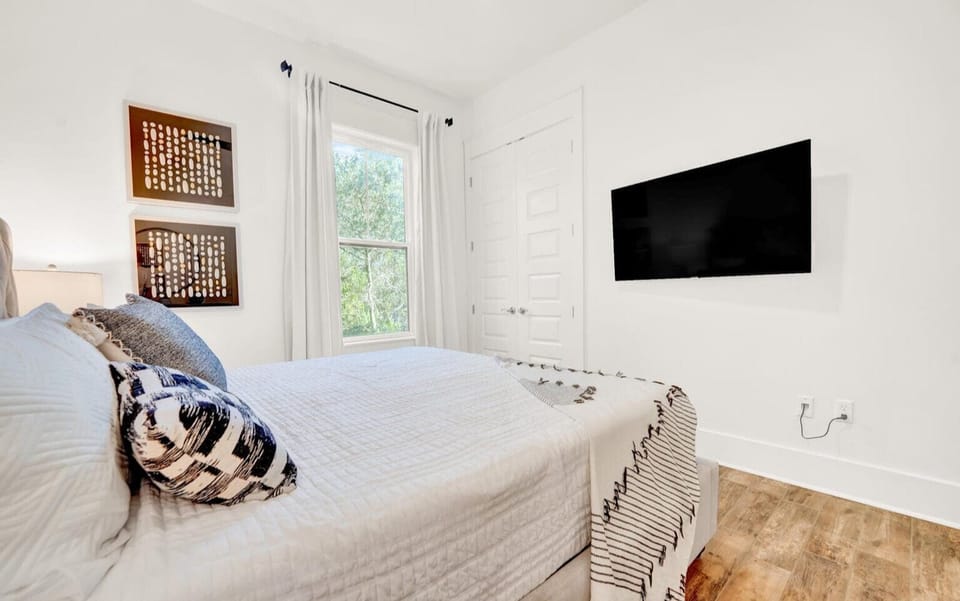 King bedroom on the main level with a 55" flat screen TV and a fan.  