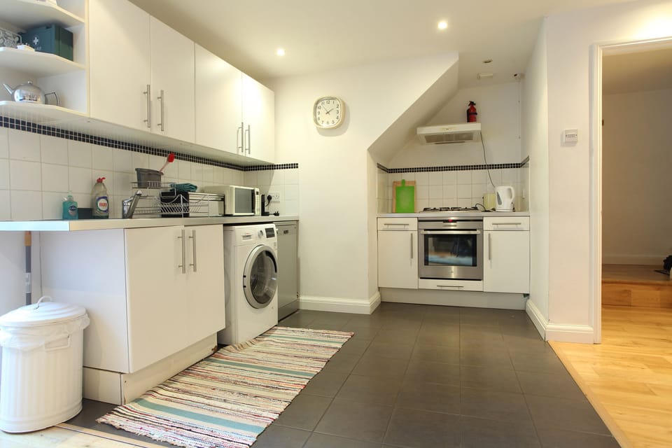 Kitchen with washer-dryer, dishwasher, oven, hob, microwave and coffee machine