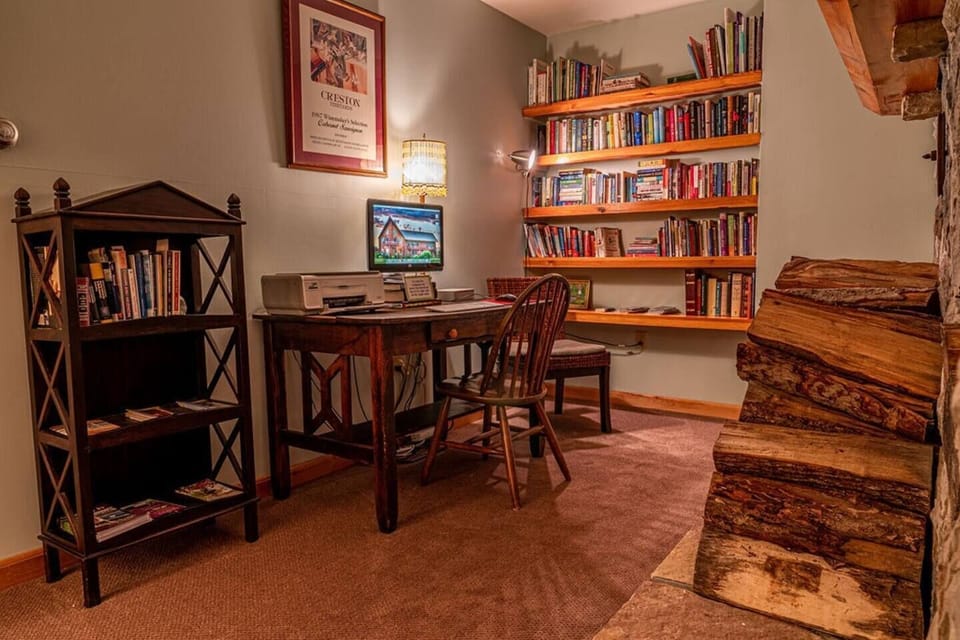 A cozy office space with computer, printer and small library provided