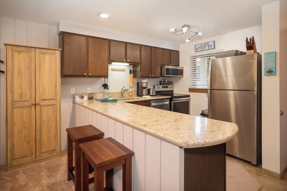 Your fully equipped kitchen awaits with granite counters, stainless appliances, and breakfast bar for morning coffee.