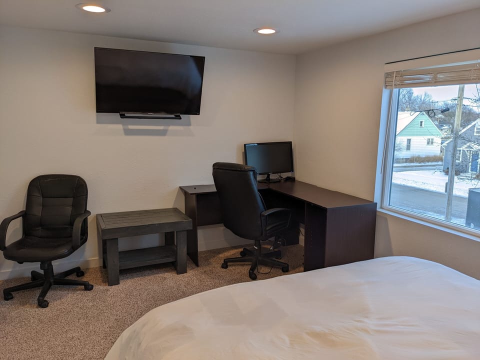 The 2nd bedroom has a desk, two office chairs, side table and extra monitor.