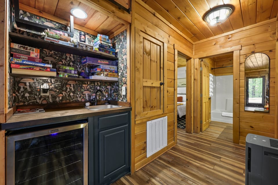 Wet bar with a beverage fridge downstairs and shelves stocked with games
