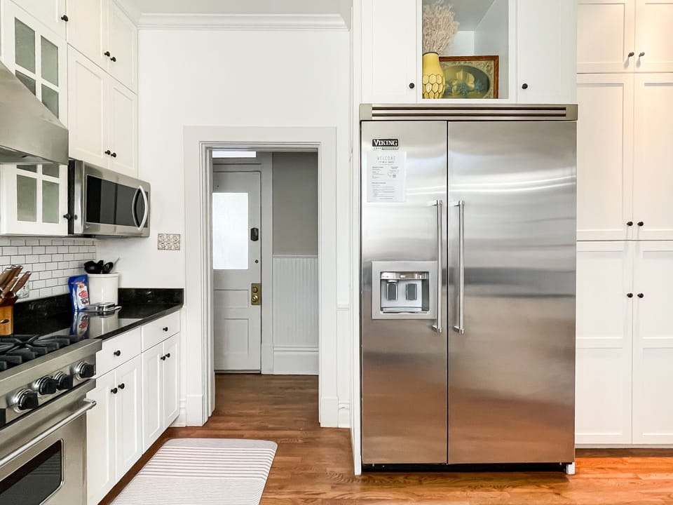The beautifully detailed full kitchen has everything you need to make your own meals, including modern appliances, place settings, pots and pans, wine glasses, and Viking fridge at Mill Haus.