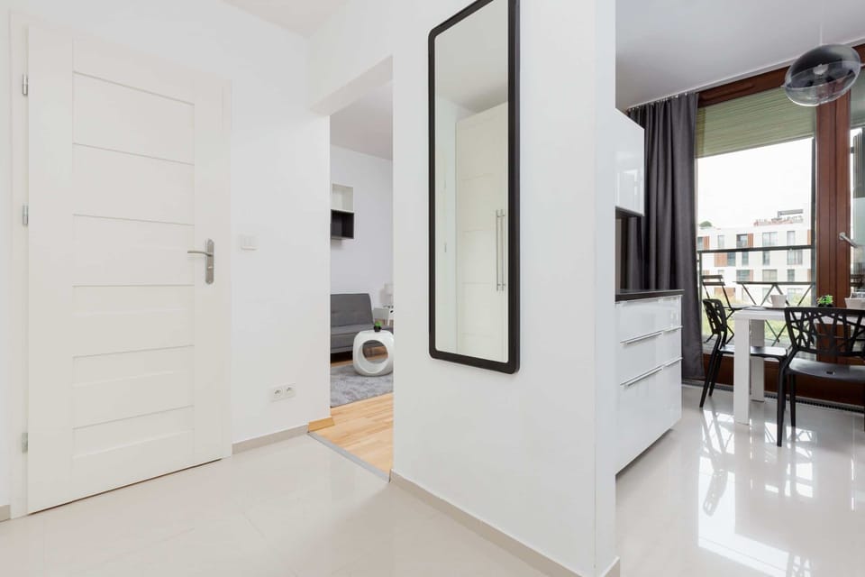 Bright hallway leading to other rooms with a large mirror on the wall.